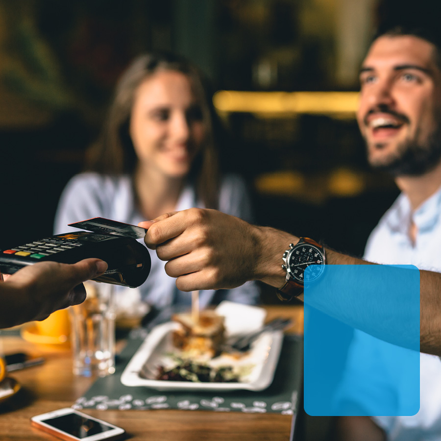 Young couple dining using a credit card.